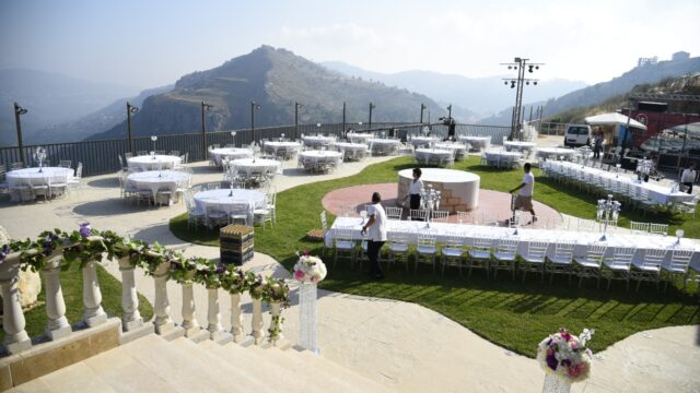 a group of people outside with tables and chairs