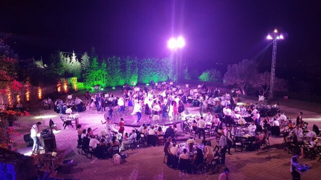 a group of people sitting around tables outside at night