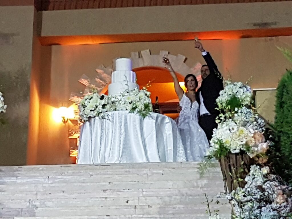 a man and woman standing on a staircase with a cake