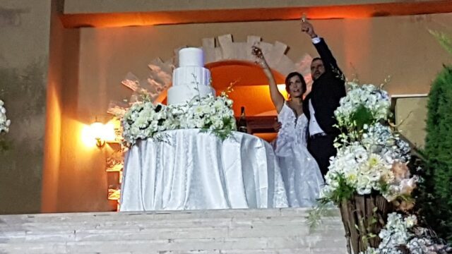 a man and woman standing on a staircase with a cake