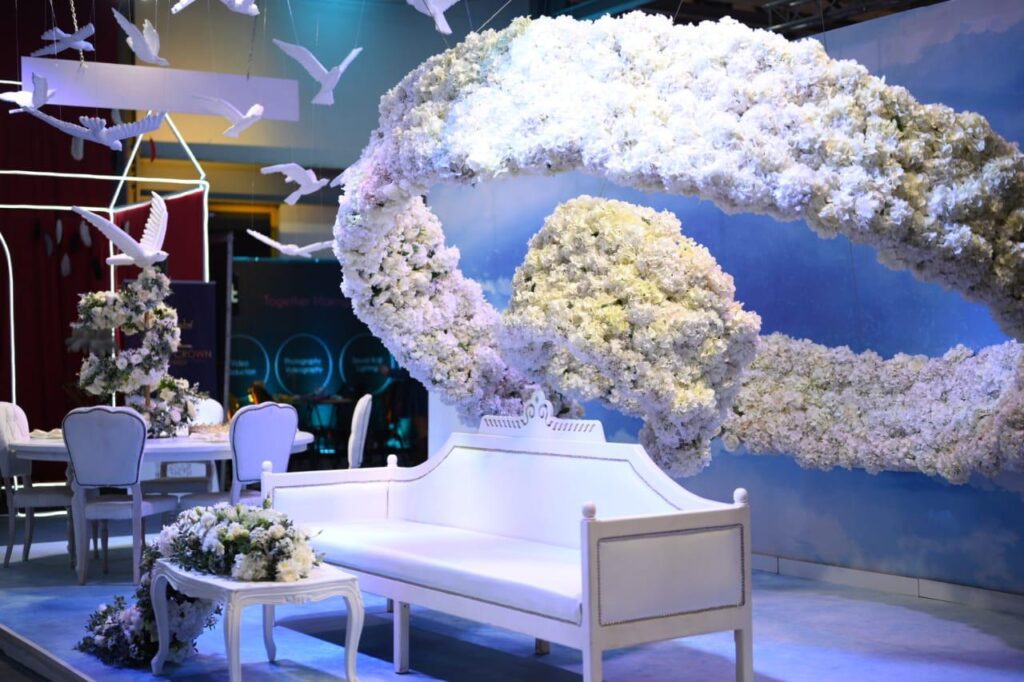 a white couch and white chairs with flowers