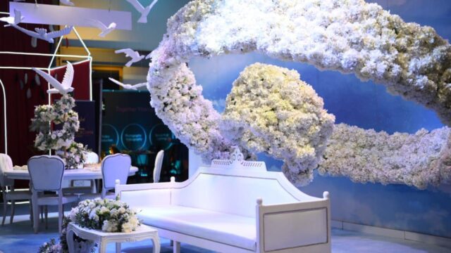 a white couch and white chairs with flowers