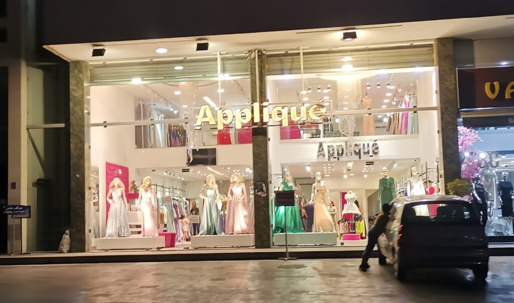 a store front with mannequins in dresses
