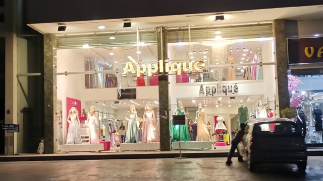 a store front with mannequins in dresses