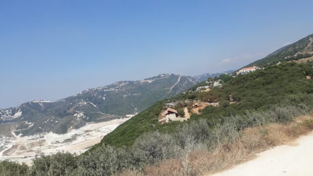 a landscape of a mountain with trees and buildings