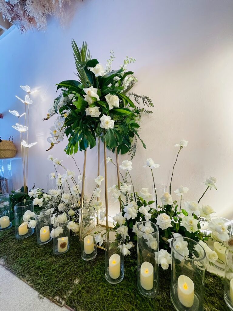 a group of white flowers and candles