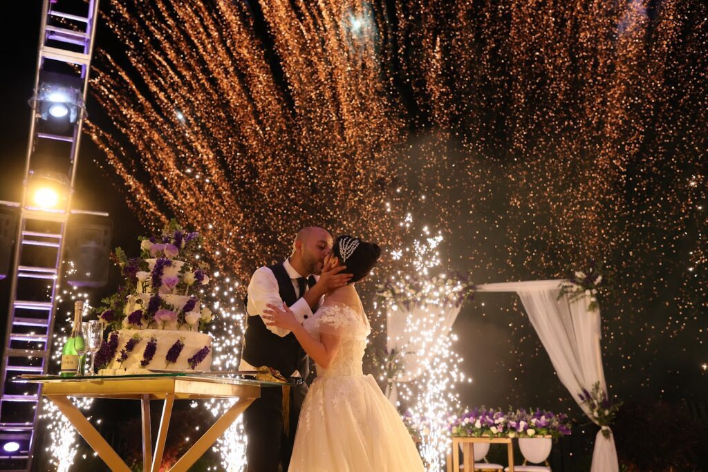 a man and woman kissing under fireworks