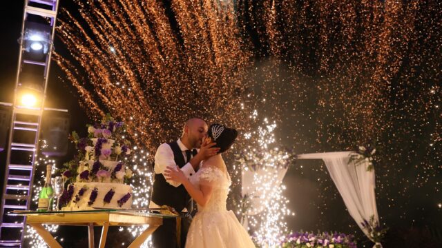 a man and woman kissing under fireworks