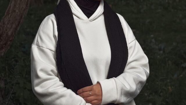 a woman in a white sweater and black scarf