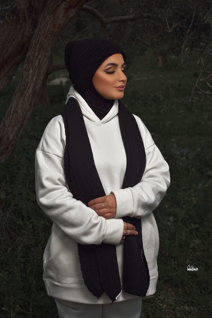 a woman in a white sweater and black scarf