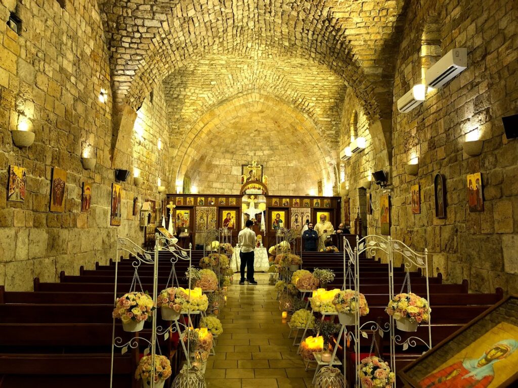 a church with flowers in the aisle with Postojna Cave in the background