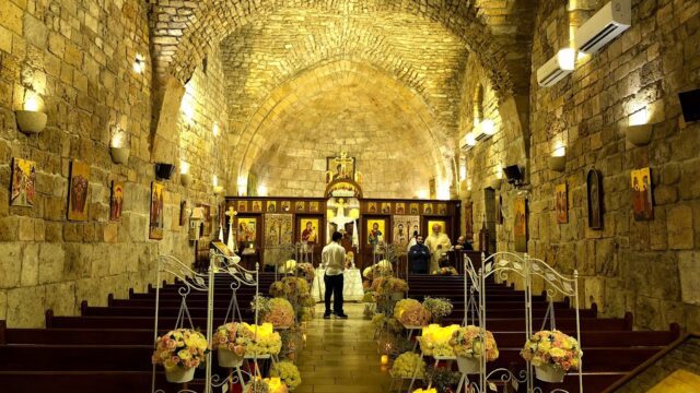 a church with flowers in the aisle with Postojna Cave in the background