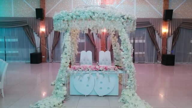 a white table with flowers and a chandelier