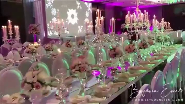 A table with candles, flowers, and Beydoun Chairs كراسي بيضون.