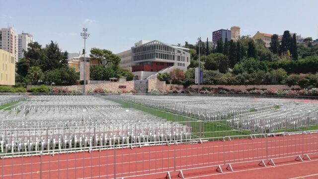 A stadium with rows of Beydoun Chairs كراسي بيضون, white seats, and a red track.