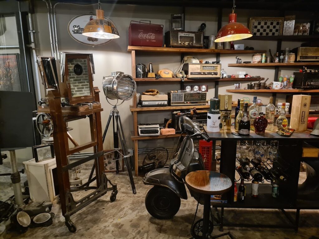 a room with shelves and shelves and a table with chairs and lamps