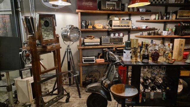 a room with shelves and shelves and a table with chairs and lamps