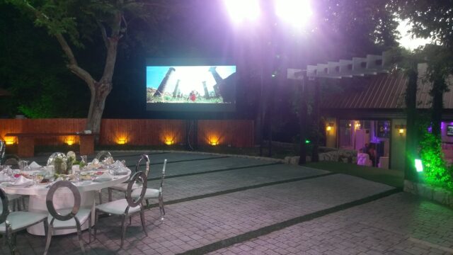 a outdoor patio with a screen and chairs