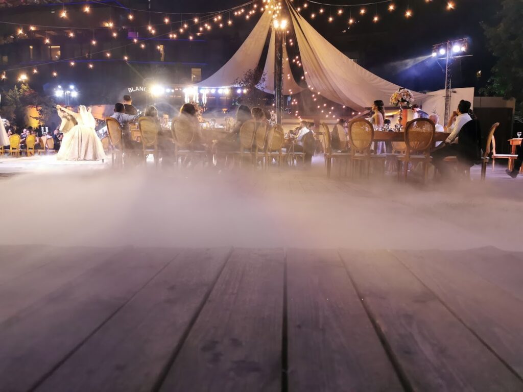 a group of people sitting at tables in front of a tent