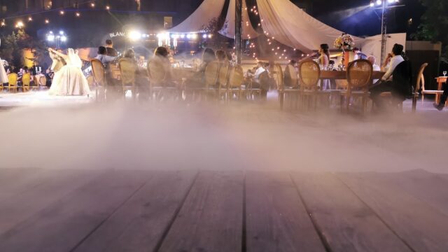 a group of people sitting at tables in front of a tent