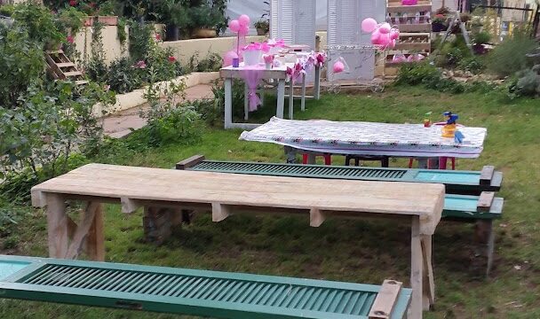 a picnic table with pink balloons from string