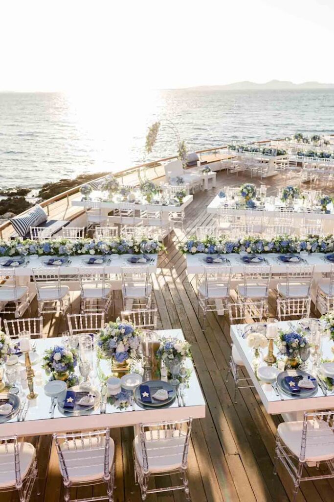 a group of tables set up on a deck with chairs and tables