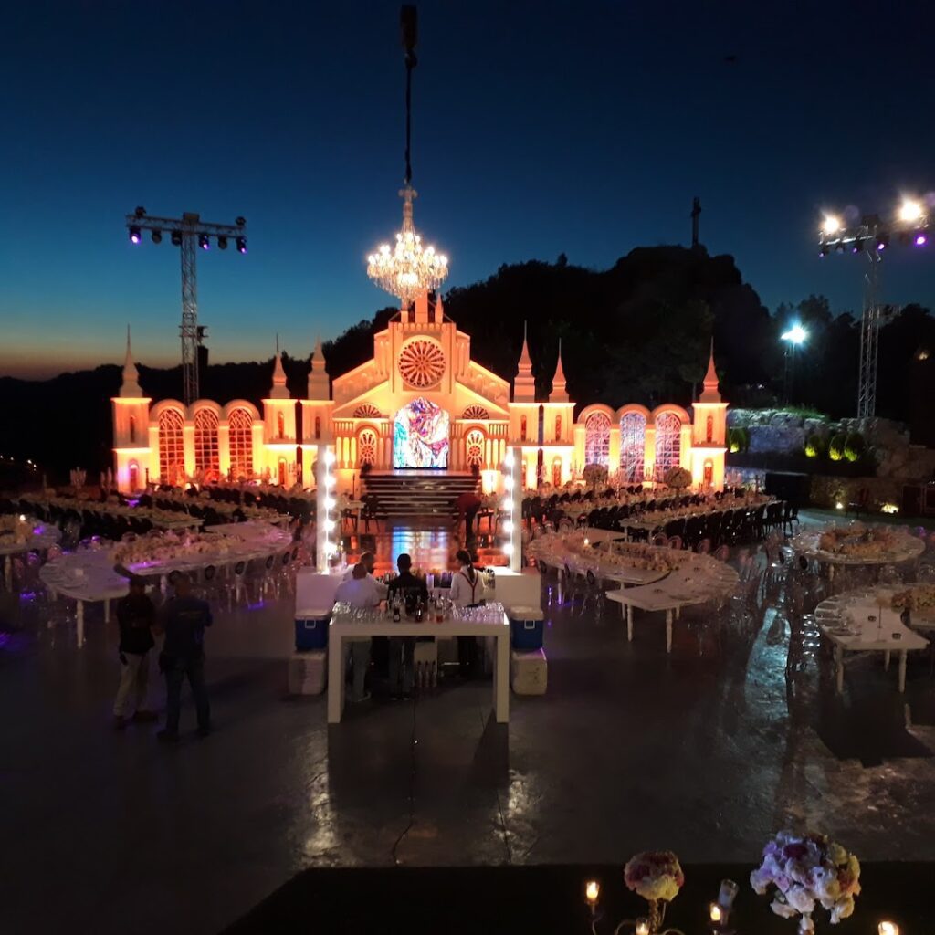 a large building with a chandelier and tables with food and people around it