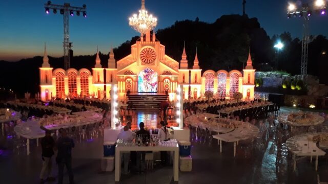 a large building with a chandelier and tables with food and people around it