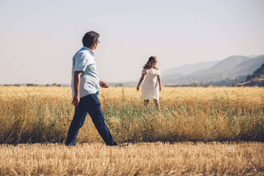 a man and woman walking in a field