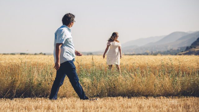 a man and woman walking in a field