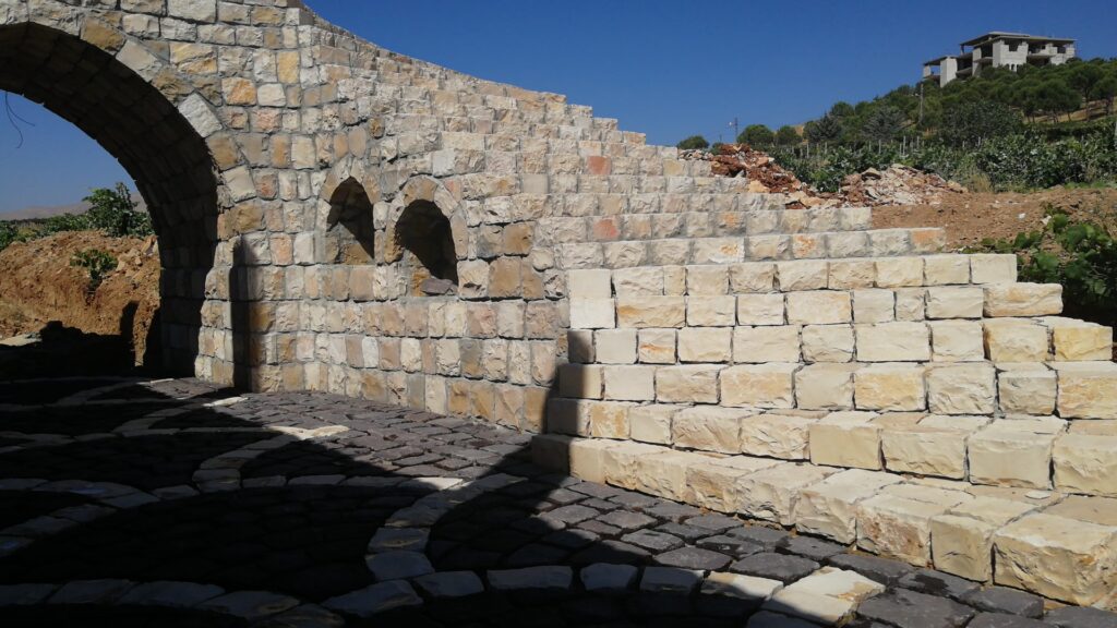 a stone wall with a stone walkway and a stone arch