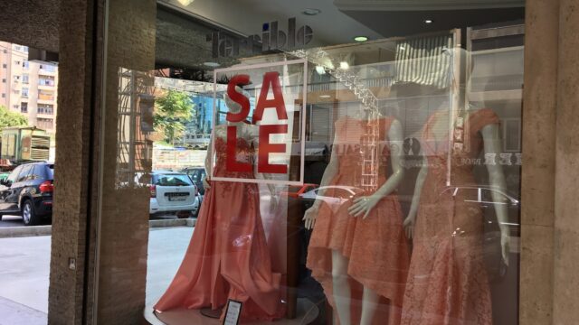 a storefront with mannequins in dresses