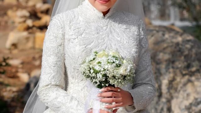 a woman in a wedding dress holding a bouquet