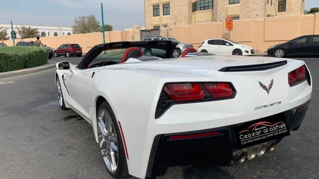 a white convertible car parked in a parking lot