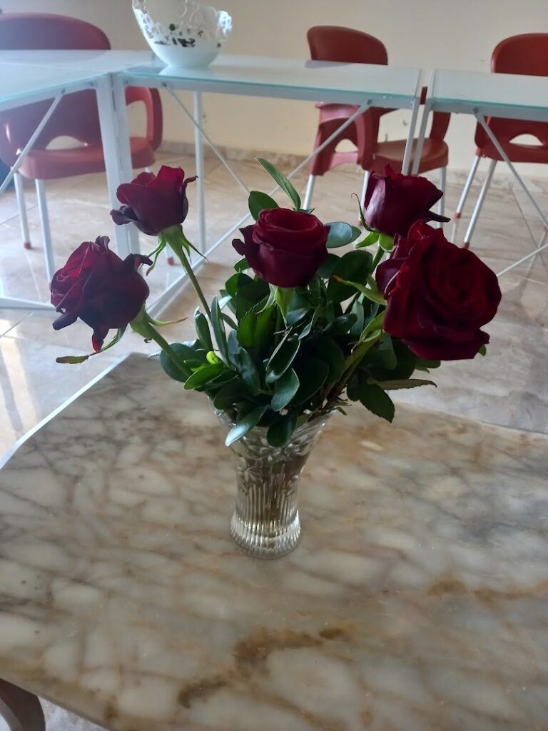 a vase of red roses on a marble table