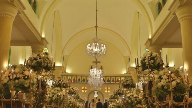 a wedding ceremony with chandeliers and flowers