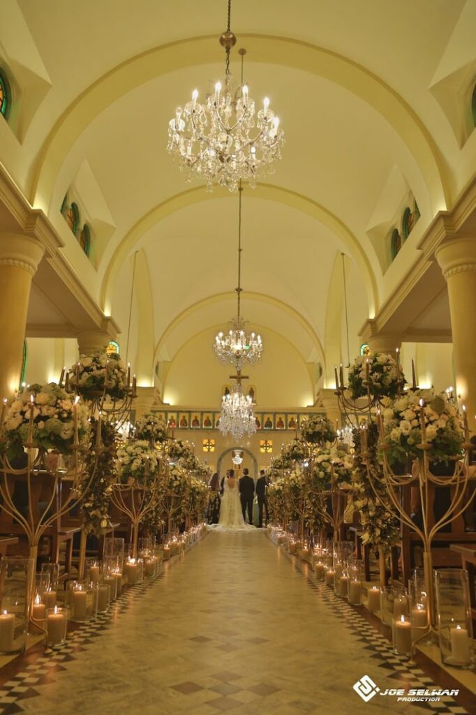 a wedding ceremony with chandeliers and flowers