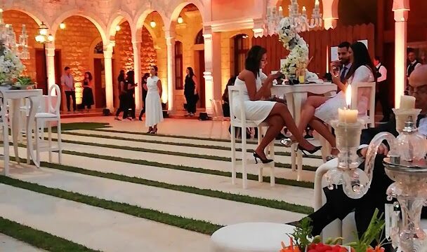 people sitting at a table in a courtyard