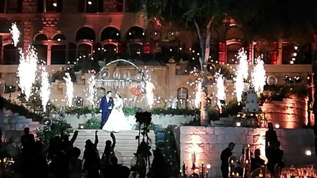 a couple on a stage with fireworks in the background