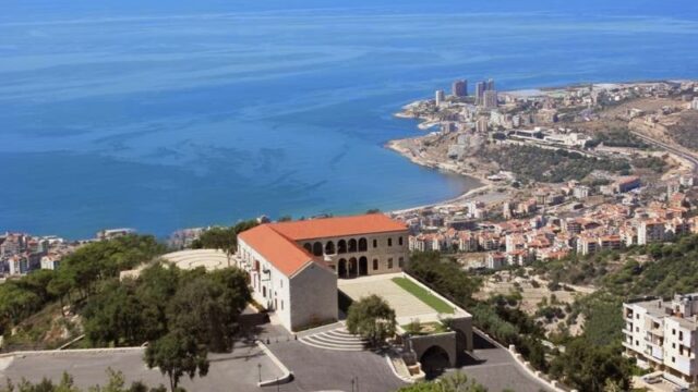 a large building with a large lawn and a large body of water