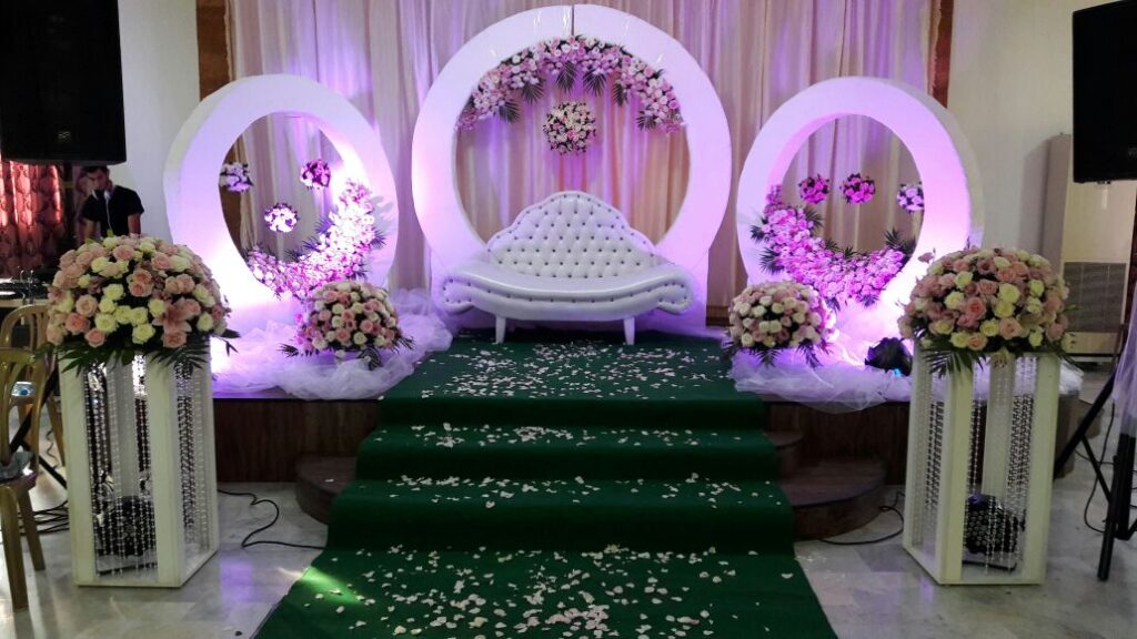 a stage with a white couch and green carpet