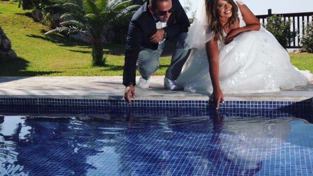 a man and woman in wedding dress by a pool