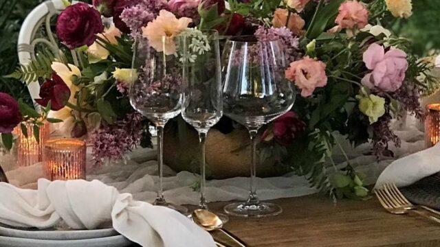 a table with wine glasses and flowers