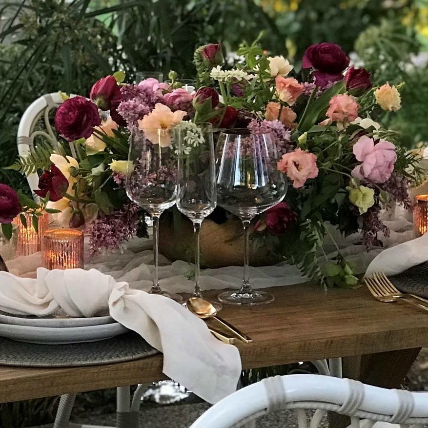 a table with wine glasses and flowers