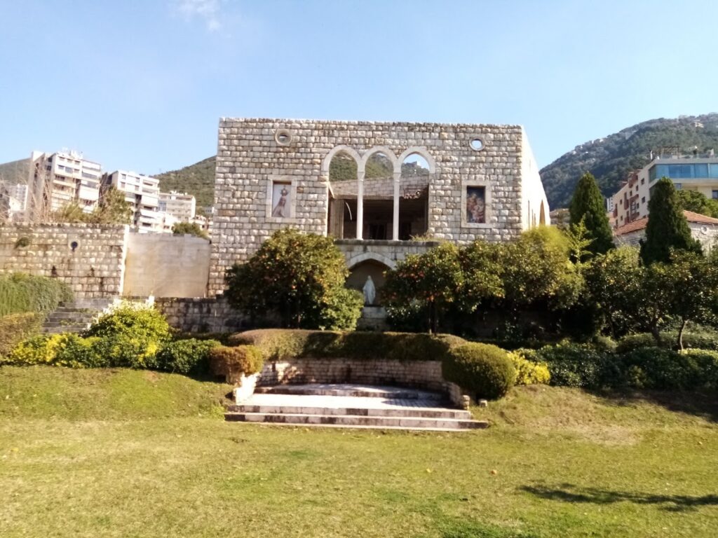 a stone building with a lawn and a fountain