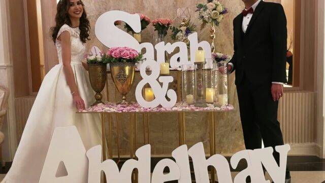 a man and woman standing next to a table with letters