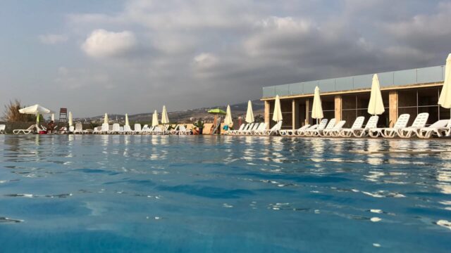 a pool with chairs and umbrellas