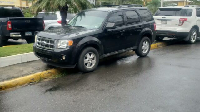 a black car parked on a wet road