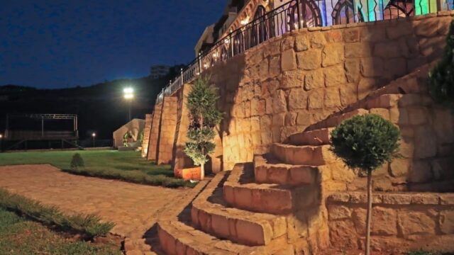 a stone wall with a fence and a walkway