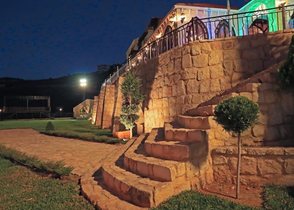 a stone wall with a fence and a walkway